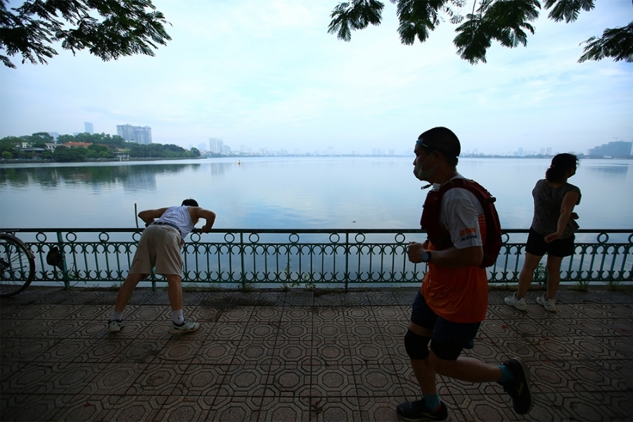 Scène de personnes faisant leurs exercices matinaux au lac Hoan Kiem.