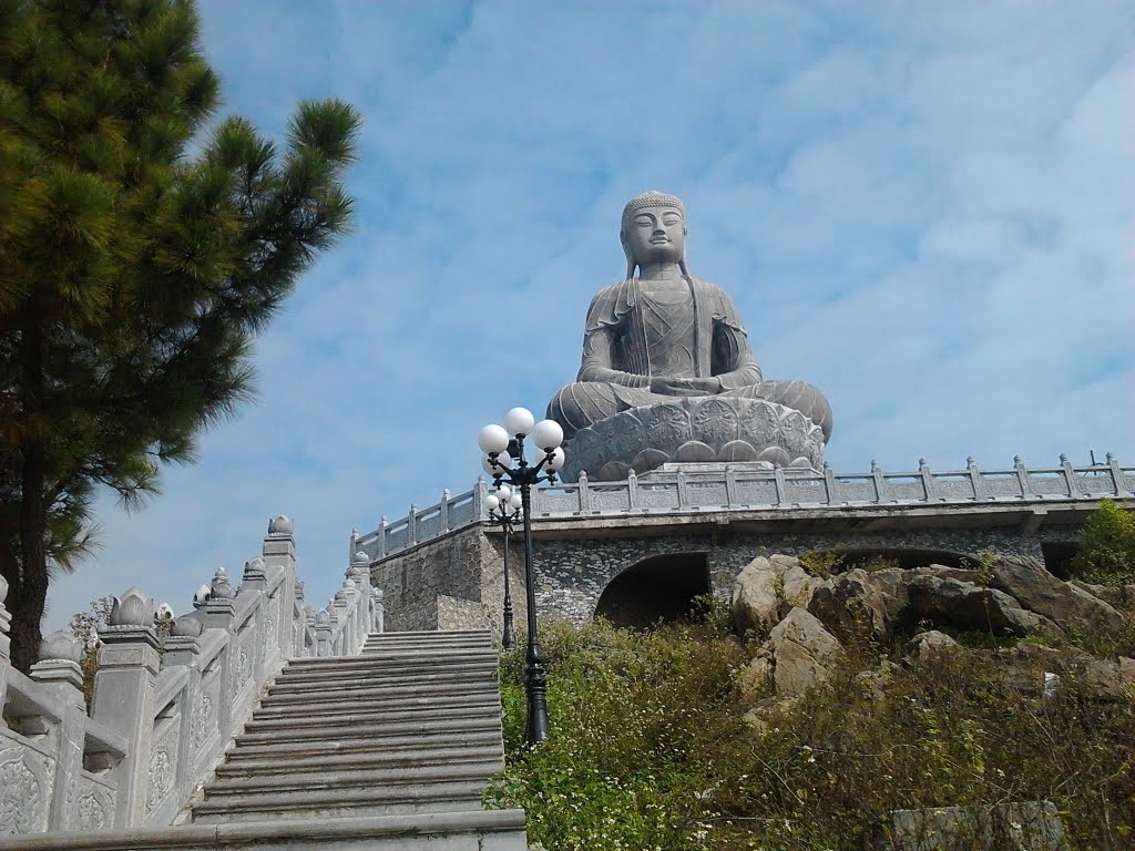 La statue en pierre verte du Bouddha Amitabha assis sur une fleur de lotus mesure 1,87 m de haut