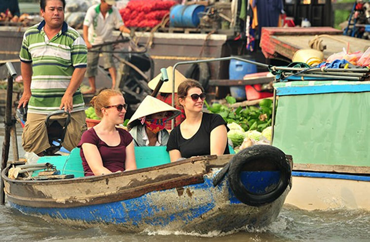 Les touristes prennent un bateau pour explorer le marché flottant