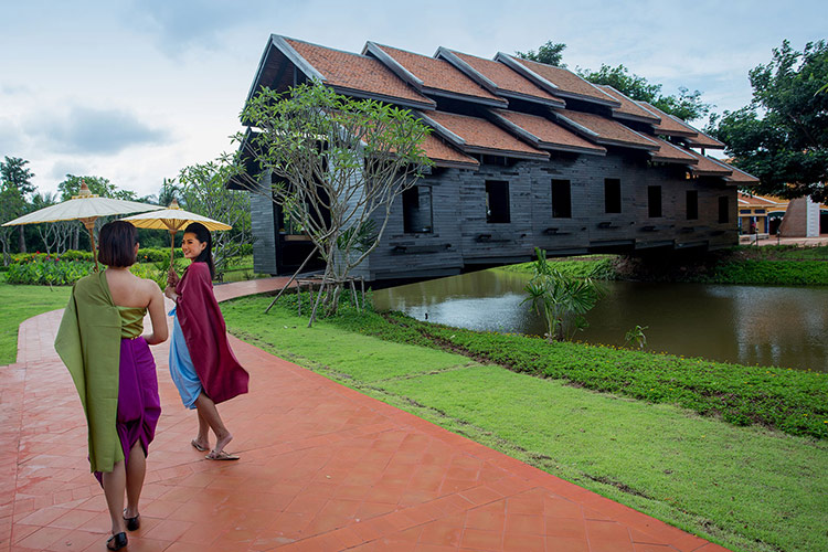 Femme en costume traditionnel thaïlandais traverse le pont Han dans la ville de Mallika