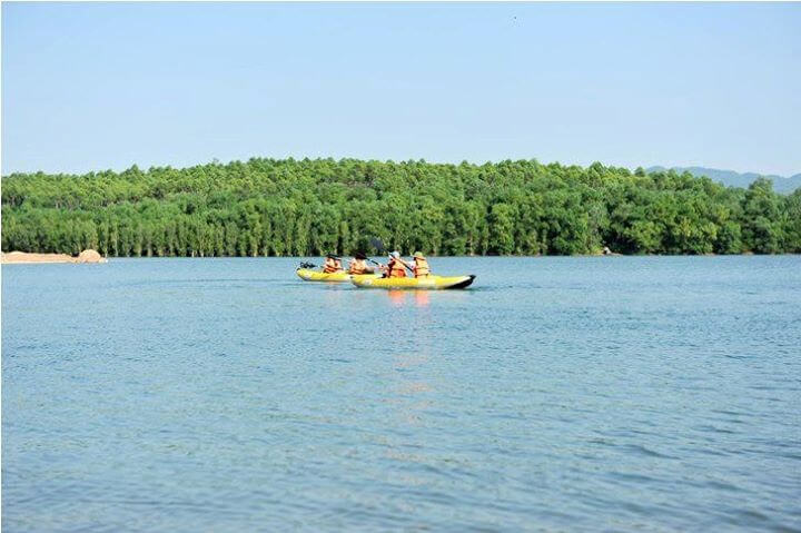 Les touristes rament des kayaks sur le lac Dai Lai