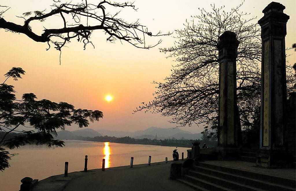 Le coucher du soleil dans la rivière des Parfums devant la pagode Thien Mu